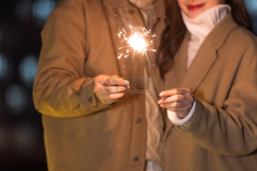秋冬夜晚情侣室外放烟花特写