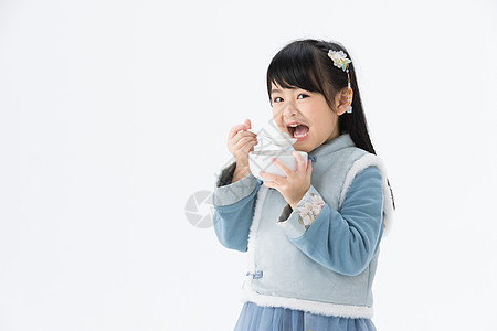 穿着淡蓝色古装的可爱小女孩吃汤圆图片