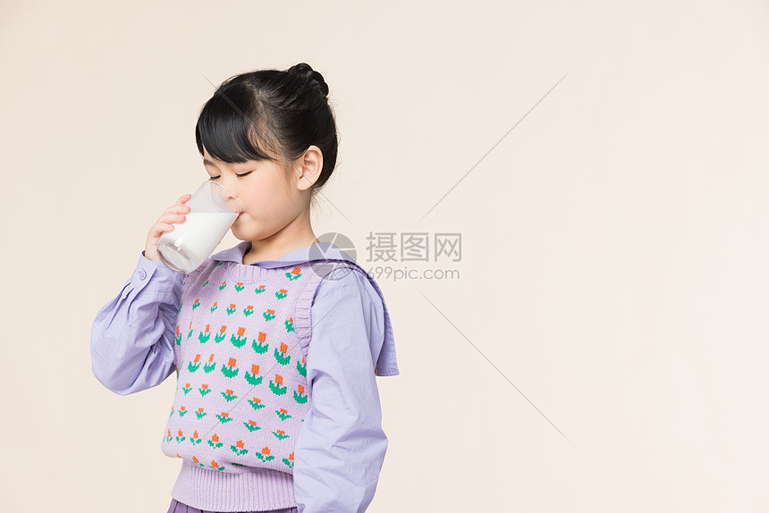 小女孩用杯子喝牛奶图片