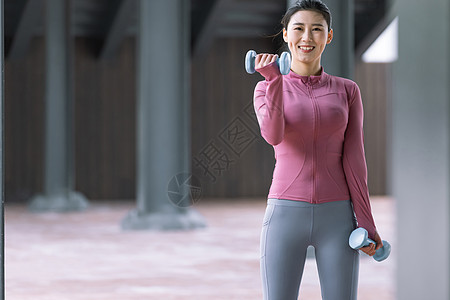 女性在户外用哑铃健身图片