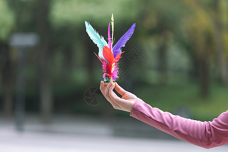 踢毽子女性拿着羽毛毽子特写背景