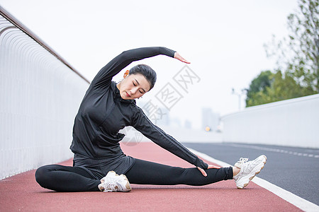 在跑道上做拉伸动作的女性图片