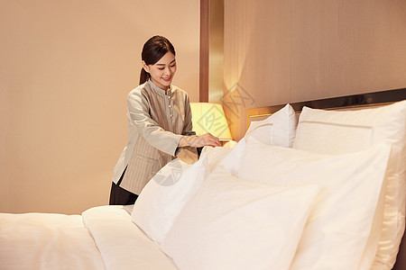 酒店服务员整理客房床铺背景图片