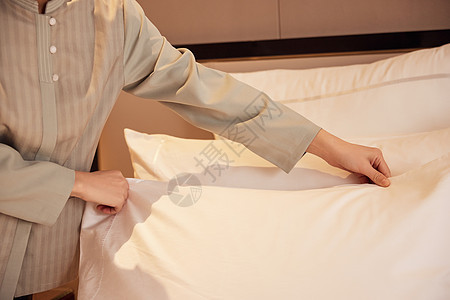 酒店服务员整理客房床铺背景图片