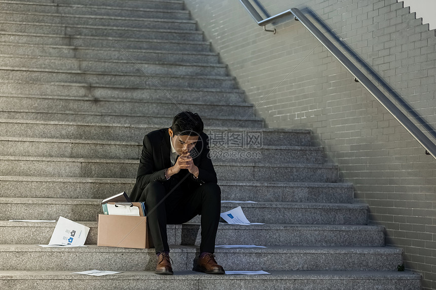 被辞退的商务男性失落的坐在楼梯上