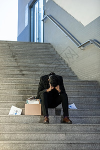 被辞退的商务男性失落的坐在楼梯上高清图片