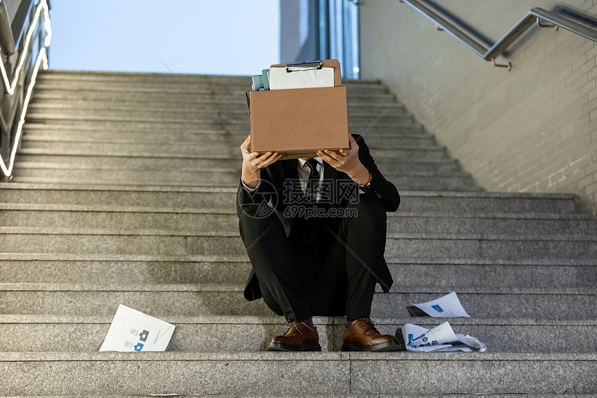 被辞退的商务男性失落的坐在楼梯上图片