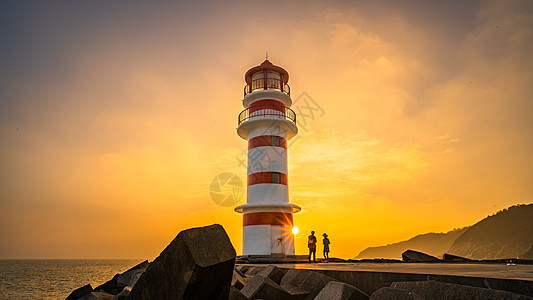 晚霞夕阳下的海边灯塔背景图片