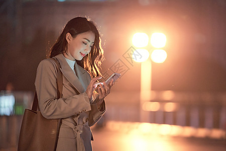 疲惫年轻女性深夜加班的都市女性使用手机打车背景