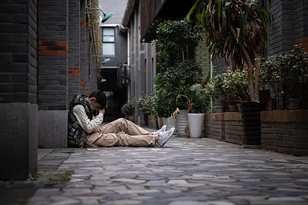 孤独自闭的青少年遭受校园欺凌蜷缩在墙角背景图片