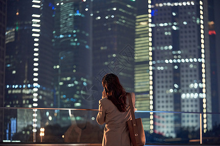 人群背影都市女性夜晚下班路上打电话背影背景