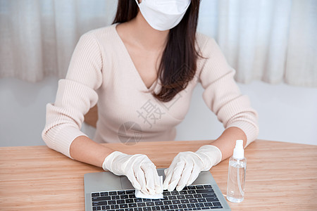 女性戴口罩居家办公清洁消毒背景图片