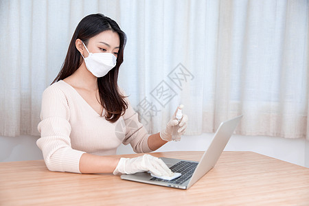 女性戴口罩居家办公清洁消毒背景图片