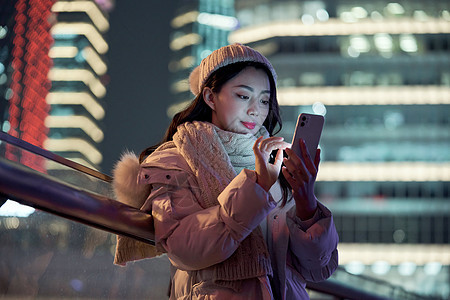 夜晚使用手机自拍的冬季女性图片