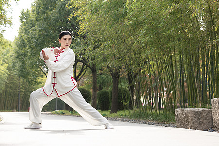 模特表演女性在公园里练习太极拳武术背景