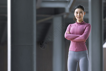 穿着健身衣双手抱胸的女性背景图片