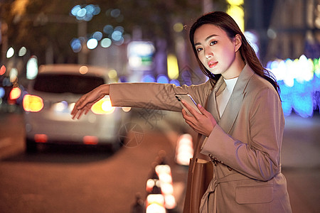 深夜街道都市女性街头呼叫网约车背景