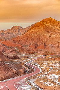 公路蜿蜒夕阳下的甘肃张掖七彩丹霞景区背景