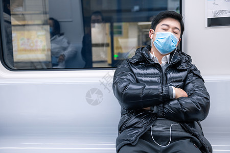 坐在地铁上睡着的男性图片