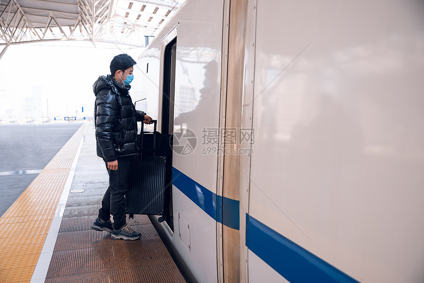 男性提着行李上火车图片