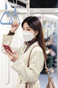疫情期间下班回家的女性在地铁低头看手机图片