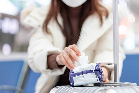 女性在火车站使用消毒湿巾特写图片