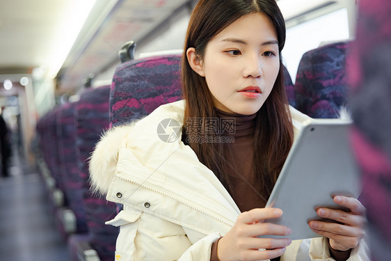 女性在火车车厢里使用平板电脑图片