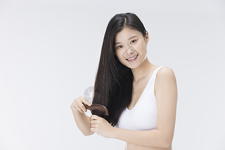 年轻女性使用梳子梳头发图片
