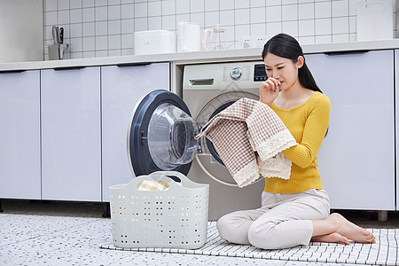 衣服女模特家庭主妇清洗衣物闻脏衣物背景