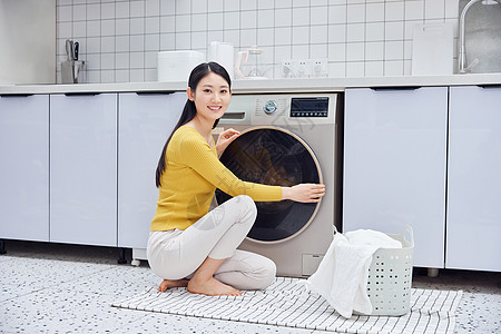 做家务的女性把脏衣服放入洗衣机高清图片