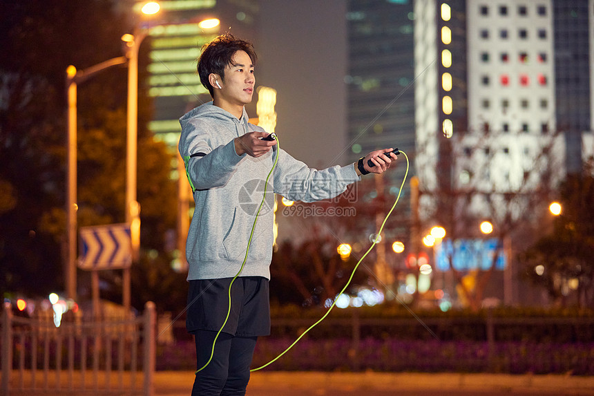 年轻男士夜晚跳绳拉伸图片