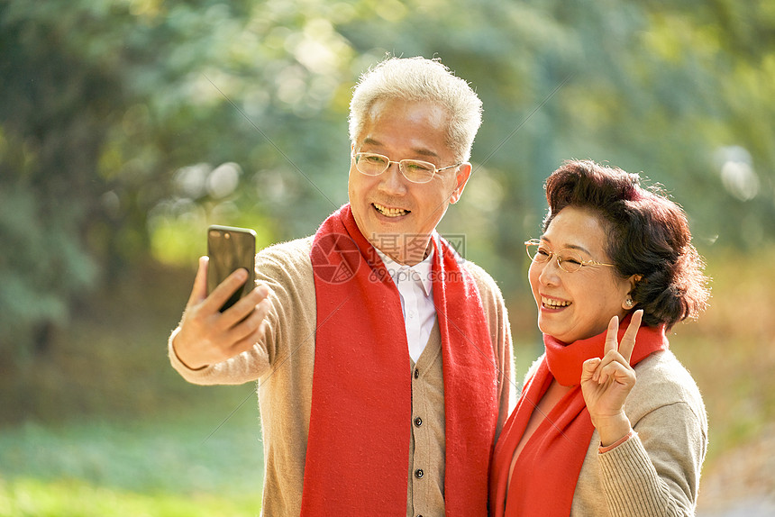 老年夫妇公园里用手机自拍图片