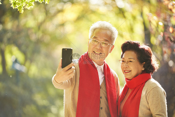 老年夫妇公园里用手机自拍图片