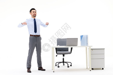 在办公桌旁舒展身体的男性背景图片