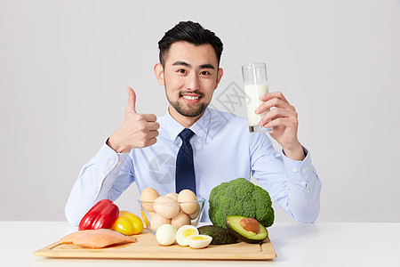 绿色食品标志健康饮食的职场男士拿着一杯牛奶点赞背景