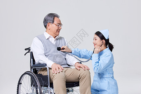 照顾老人护士为行动不便的老人检查心脏背景