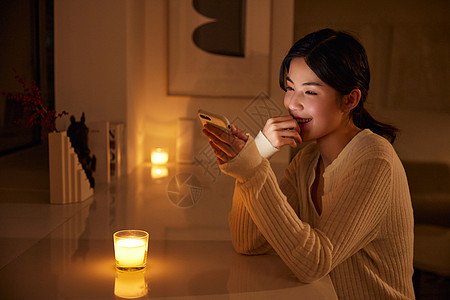 居家背景深夜熬夜玩手机的年轻女性背景