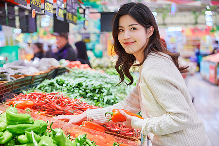 购物美女年轻女性超市挑选购买蔬菜背景