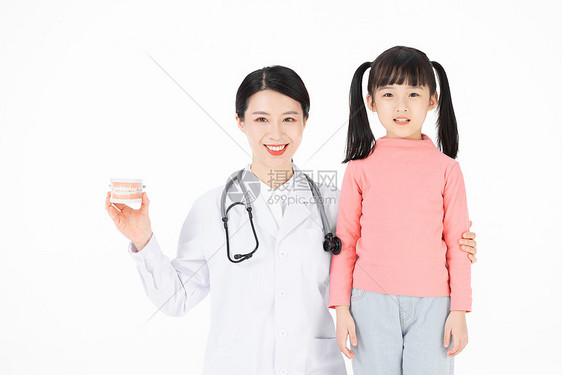 手拿牙齿模型的医生与小女孩图片