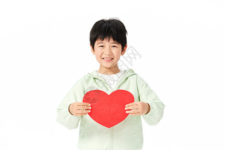 小男孩把红色的爱心举到胸前背景图片