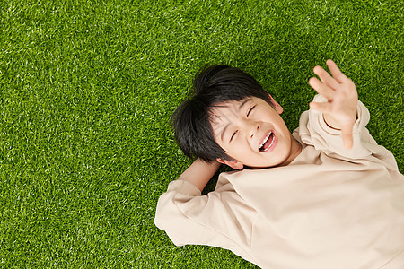 孩子躺在草坪上开心的躺在草坪上的小男孩背景
