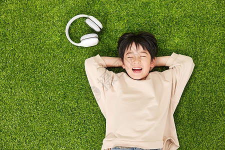 孩子躺在草坪上躺在草坪上的小男孩背景