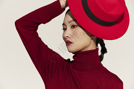 手拿红色礼帽的时尚美女背景图片