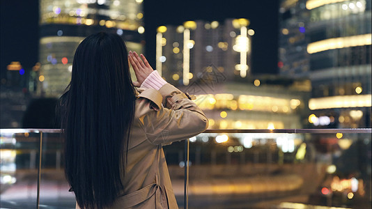 冬天美女年轻美女对着城市呐喊背影背景