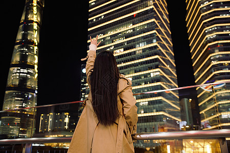 手机励志冬季夜晚都市女性人像举手欢呼背景