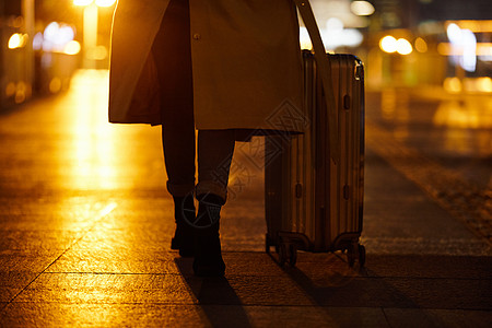 女性职场背影夜晚都市女性手提行李箱走在路上背景