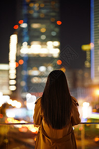 手机背影冬季夜晚都市女性人像背影背景