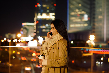 职员阳台打电话都市女性夜晚手握咖啡杯打电话背景