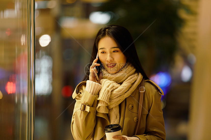 都市女性夜晚手握咖啡杯打电话图片