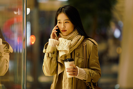 手机打电话都市女性夜晚手握咖啡杯打电话背景